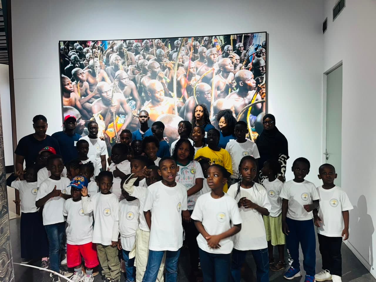 Élèves de Natal e Xàlaat en t-shirts de la campagne devant leur exposition